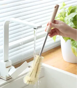 Long handle cup brush detail showing nylon bristles and wooden handle cleaning in sink.