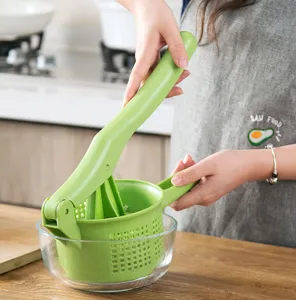 Vista detallada del exprimidor manual de verduras en la cocina, con cesta verde duradera.