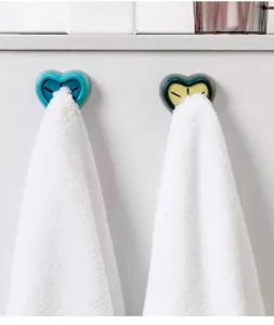 Detail view of heart-shaped wall-mounted towel plug and silicone holder for kitchen and bathroom.