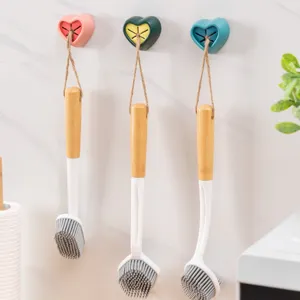 Heart-shaped wall-mounted towel holder and silicone rag plug for kitchen and bathroom organization.