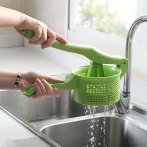 Exprimidor de verduras manual, herramienta de cocina, colador de frutas de plástico verde.