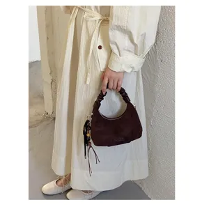 Détail du sac à main en suédine, élégant sac hobo marron d'automne poignée froncée.