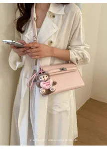 Pink crocodile pattern shoulder crossbody bag with cute bear plush keychain and lock.