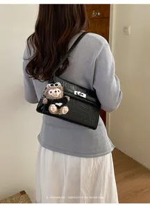 Black crocodile pattern shoulder bag with cute plush bear pendant for women stylish daily use.