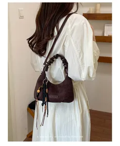 Élégant sac porté épaule en daim marron pour femme, avec poignée froncée et beaux détails.