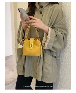 Borsa a secchiello in camoscio stile Maillard con manico intrecciato e chiusura chic.