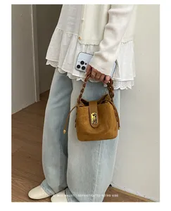 Borsa a secchiello in scamosciato marrone con manico intrecciato e chiusura. Stile retro.