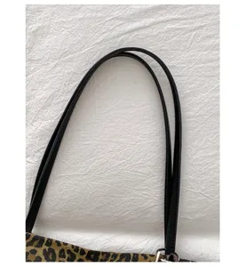 Leopard print tote bag black shoulder strap detail closeup, fashion commuting handbag feature.