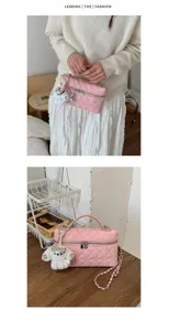 Vue détaillée du sac vanity matelassé rose à chaîne avec charm, style élégant et chic.