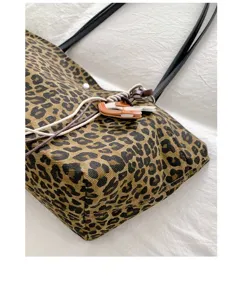 Chic leopard print tote bag with black straps and leather charms detail for daily commute.