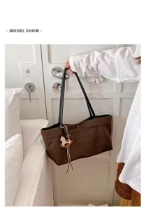 Brown canvas tote bag with shoulder strap and horse charm, casual daily commuting design.