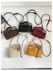Detailed view of retro woven texture crossbody lunch box bag with cute flower pendant.