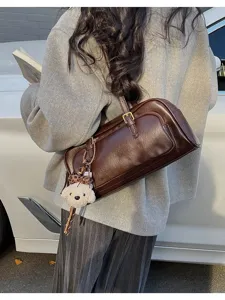 Vintage brown leather baguette shoulder bag for women, chic underarm purse with bear.