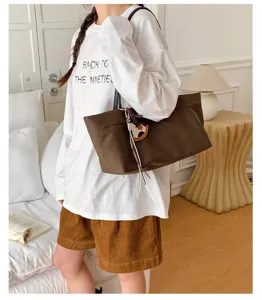 Large capacity canvas shoulder tote bag with cute horse charm and stylish commuting design.