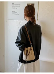 Detailansicht einer Vintage PU Wildleder Beuteltasche mit braunem Kordelzug im Lifestyle.