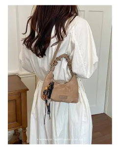 Élégant sac à bandoulière en suède marron avec poignée froncée et charme chic.