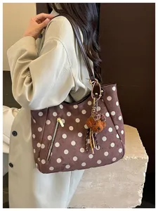 Nahaufnahme der retro Wildleder Punkte Schultertasche mit Bärenanhänger und Reißverschlusstasche.
