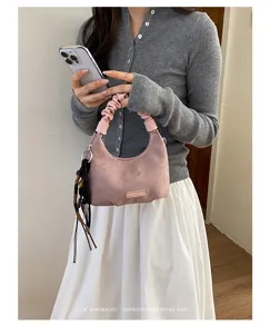 Sac à main bandoulière en suédine rose pour femme, élégant sac hobo avec frange noire chic.