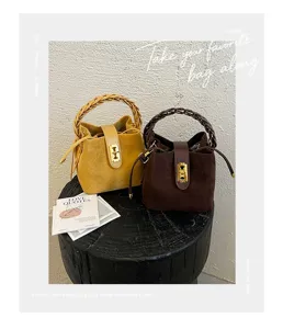 Borsa a secchiello in camoscio stile Maillard con manico intrecciato e serratura. Elegante borsa.