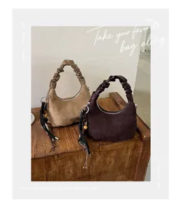 Vue détaillée du sac porté épaule rétro en suédine pour femme avec poignée froncée et charms.