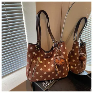 Braune Pünktchen Wildleder Tote Tasche Detail mit Reißverschluss und Bärenanhänger.