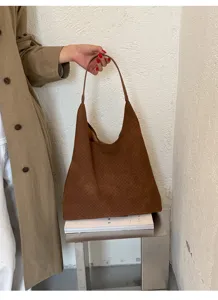 Dettaglio borsa shopper intrecciata marrone con texture raffinata e design elegante.