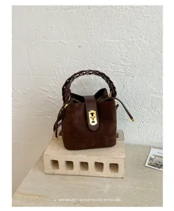 Borsa a secchiello in scamosciato marrone con manico intrecciato e chiusura in metallo.