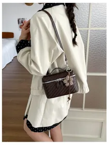 Detailed shot of a vintage woven box bag worn on shoulder, stylish commuter handbag.