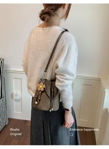 Stilvolle minimalistische Kordelzug Beuteltasche aus Wildleder mit Blumenanhänger.