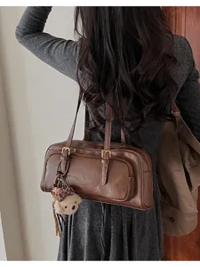 Vintage brown leather baguette shoulder bag for women, stylish commuter underarm tote purse.
