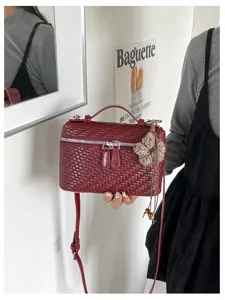 Detail view of the retro woven vanity bag, featuring detailed leather texture and charm.