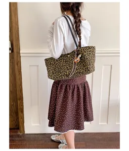 Leopard print tote bag detail showing large capacity, cute horse charm and shoulder straps.