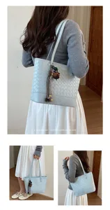 Details van de minimalistische retro geweven shopper met fijne textuur en bijpassende bedels.