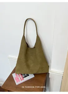 Vista dettagliata della borsa a spalla intrecciata in kaki, ideale per look da lavoro.