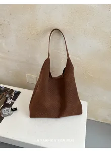 Dettaglio borsa shopper intrecciata marrone che mostra la raffinata lavorazione in pelle.