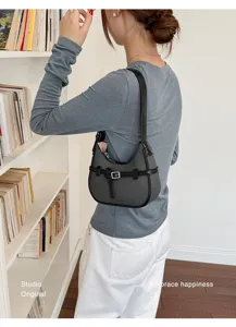 Vista dettagliata della borsa a spalla texturizzata indossata dalla modella ogni giorno.