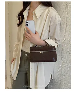 Detail view of retro brown suede vanity bag, compact top-handle design with zipper.