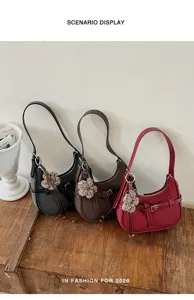 Vista dettagliata della borsa a spalla tessuta da donna con ciondolo a fiore lavorato a maglia.