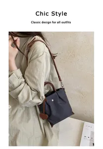 Gros plan détaillé du sac seau élégant en nylon avec bandoulière en cuir et charm en cœur.