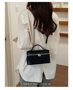 Detailed view of the black retro suede vanity bag worn on shoulder, showcasing metal zipper.