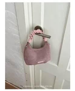 Vue détaillée du sac porté épaule femme en suédine mode, poignée froncée rose, sac rétro.