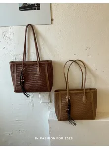 Detailed view of women woven tote bag with tassel charm, vintage shoulder bag style for commute.