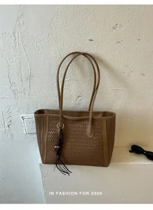 Detail view of the elegant brown woven leather tote bag, showing premium texture and craft.