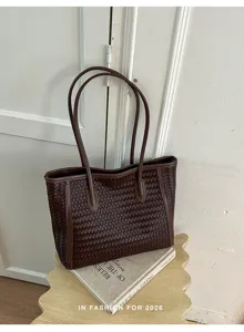 Detailed view of a vintage brown woven leather tote bag with double handles and texture.