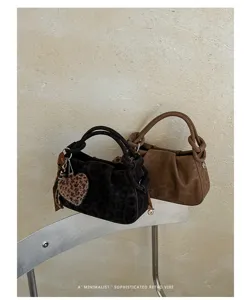 Detailed view of retro pleated leopard cloud bag with plush heart charm and metallic chair scene.