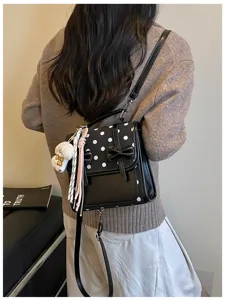 Sweet polka dot backpack detail view, featuring cute bow decor and lovely plush bear pendant.