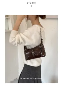 Detailed view of women stylish brown oil wax leather hobo shoulder bag with front buckle.