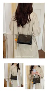Vista detallada del elegante bolso de hombro tipo almohada de ante y cuero retro de otoño.