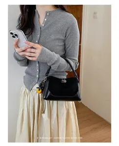 Vista detallada de un bolso de hombro tipo almohada patchwork negro retro para mujer.