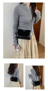 Vista detallada del elegante bolso de hombro retro negro usado por la modelo elegante.